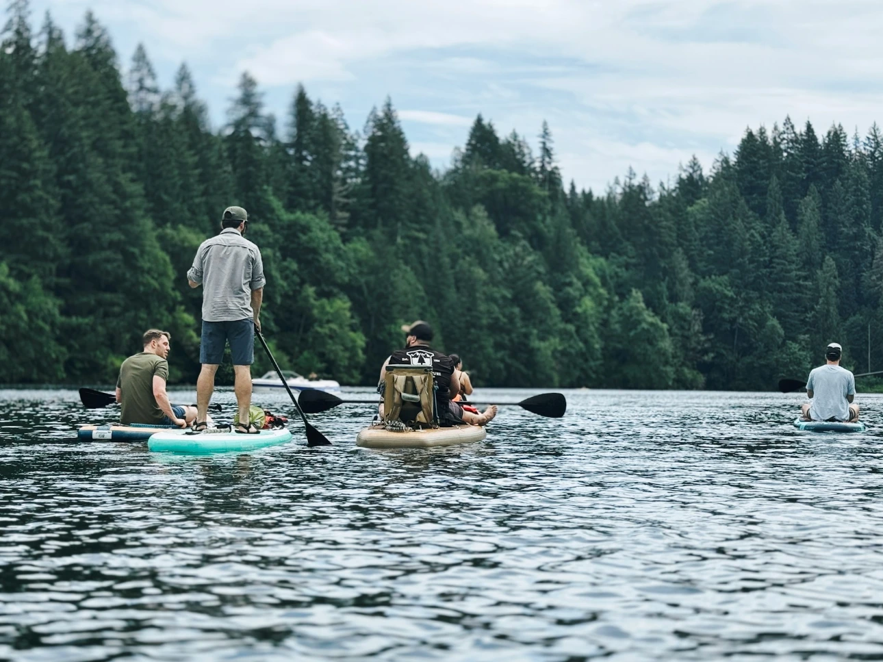 A group of people riding paddle boards on top of a lake